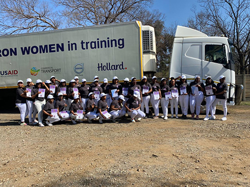 WIWIT participants huddle together in front of a large truck
