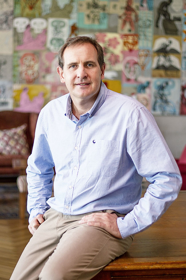 Willie Lategan, CEO of Hollard Insure, casually sitting on the corner of a table