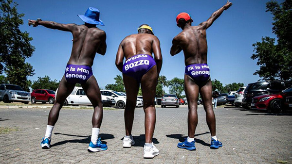 Three Daredevil Run participants posing in their speedos with their backs to the camera