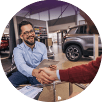 Motor dealership representative shaking hands with a customer
