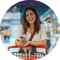 Customer using a smartphone while shopping with a trolley