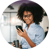 Professional using a smartphone while holding a coffee