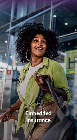 Traveller using a smartphone, illustrating embedded insurance for travel.