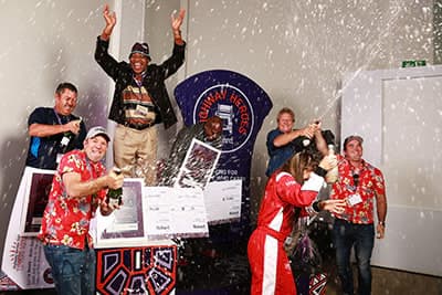 Highway Heroes winner Stephen Meje celebrating on stage with champagne and award presentation