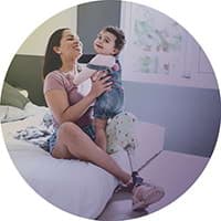 A happy Hollard client with the Disability Plus benefit, holding up her toddler.