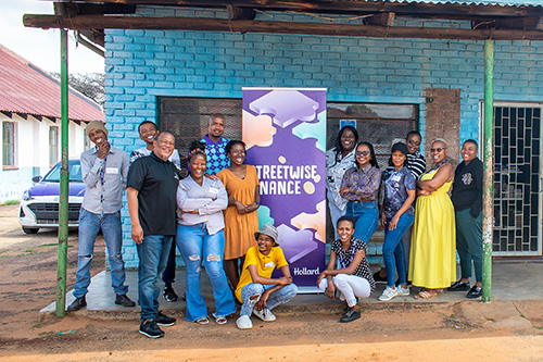 Hollard team and students standing by the Streetwise Finance sign for the Rural SMME project