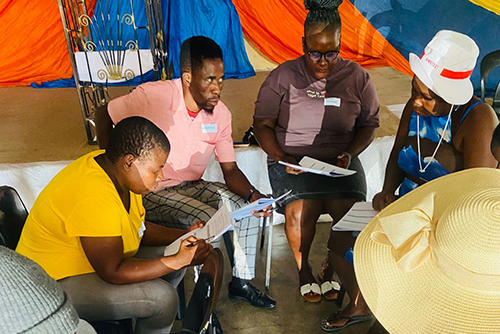 Students discussing their papers in a circle for the Hollard Streetwise Finance Rural SMME project
