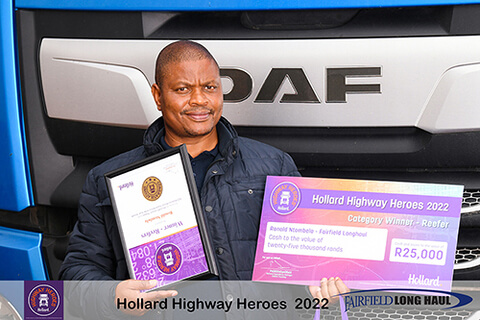 Ronald Ntombela standing with his award by a truck