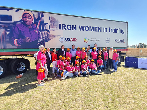 Women Inspiring Women to Lead in Transport (WIWIT) Ladies  wearing pink gathered in front of a large truck