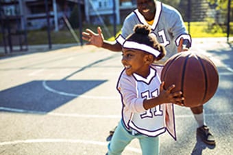Healthy Hollard Critical Illness cover client playing basketball with his daughter.